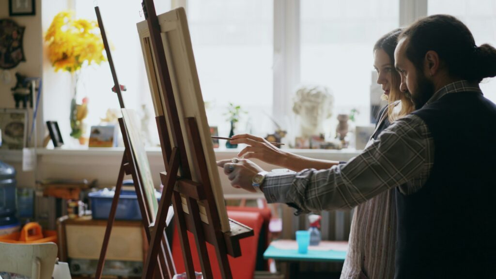 “Art instructor guiding a student at an easel during a painting session in a bright studio.”
Photo by Vitaly Gariev on Unsplash
https://unsplash.com/photos/two-artists-painting-in-a-bright-studio-3AfMM8pi5w8