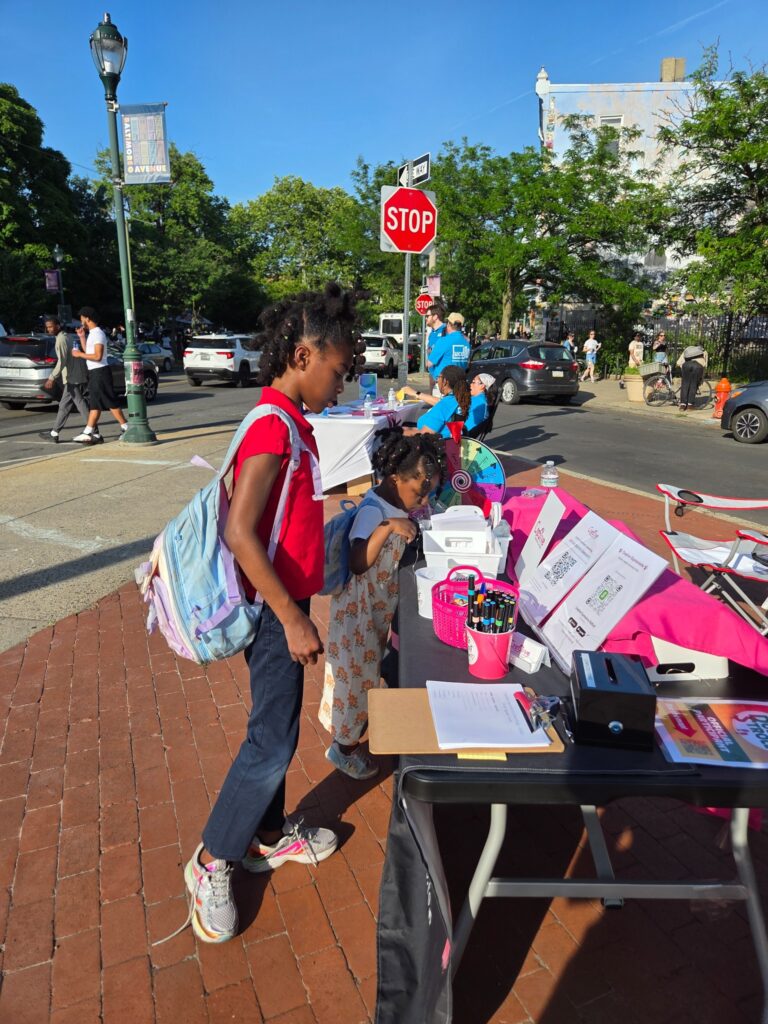 Children and community members participating in interactive activities at a Creative Expressions community event in Philadelphia.